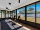 Enclosed sunroom with tiled flooring, ceiling fan, and windows offering a view of the backyard at 1210 Marlow St, Port Charlotte, FL 33952