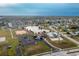 Community aerial view showcases amenities including a pool, clubhouse, tennis courts, and a scenic lake at 13449 Muriel Ave, Port Charlotte, FL 33981