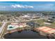 This aerial view showcases the community pool, tennis courts, and nearby lake for recreation and beautiful scenery at 13449 Muriel Ave, Port Charlotte, FL 33981