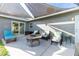 Outdoor patio area features wicker seating, a fire pit, and a sun sail, perfect for outdoor entertaining at 13449 Muriel Ave, Port Charlotte, FL 33981