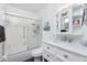 Bright bathroom featuring a tub, a white vanity with drawers, and a mirrored medicine cabinet with decorative butterfly decals at 13449 Muriel Ave, Port Charlotte, FL 33981