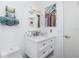 Bright bathroom featuring a white vanity with drawers, a mirrored medicine cabinet, and colorful woven decor on the wall at 13449 Muriel Ave, Port Charlotte, FL 33981