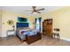 Bedroom with bright yellow walls, wood floors, and bench at the end of the bed at 13449 Muriel Ave, Port Charlotte, FL 33981