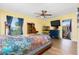 Bedroom with yellow walls, ceiling fan, and multicolored bedspread at 13449 Muriel Ave, Port Charlotte, FL 33981