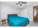 Bedroom with light gray walls, ceiling fan, wood floors, and a bed with a teal bedspread at 13449 Muriel Ave, Port Charlotte, FL 33981