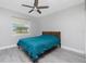 Bedroom with ceiling fan, window, wood floors and bed with teal bedding at 13449 Muriel Ave, Port Charlotte, FL 33981