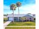 Charming single-story home with a well-maintained lawn, mature trees, and an attached garage at 13449 Muriel Ave, Port Charlotte, FL 33981