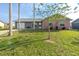 Charming home with a well-maintained lawn, colorful shrubs, and a brick facade at 13449 Muriel Ave, Port Charlotte, FL 33981