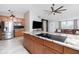 Well-lit kitchen boasting an island cooktop, stainless steel refrigerator, and modern finishes at 13449 Muriel Ave, Port Charlotte, FL 33981