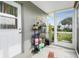 Comfortable lanai featuring a lounge chair, shelving with plants, and a view of the landscaped yard at 13449 Muriel Ave, Port Charlotte, FL 33981