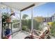 Enclosed lanai with a view of the beautiful garden, a wooden chair with floral cushions, and orchids on a plant stand at 13449 Muriel Ave, Port Charlotte, FL 33981