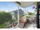 Relaxing lanai featuring a floral lounge chair and views of the landscaped yard, perfect for enjoying the outdoors at 13449 Muriel Ave, Port Charlotte, FL 33981