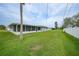 Large backyard with freshly mowed lawn and view of the screened in patio at 1756 Elinor Pl, Englewood, FL 34223