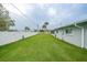 Large backyard with freshly mowed lawn and white fence at 1756 Elinor Pl, Englewood, FL 34223