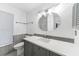 Bright bathroom with gray cabinets, a unique mirror, and modern fixtures at 1756 Elinor Pl, Englewood, FL 34223