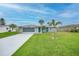 Charming single-story home with a well-manicured lawn and mature palm trees at 1756 Elinor Pl, Englewood, FL 34223