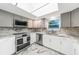 Modern kitchen featuring gray cabinets, stainless appliances, and stunning countertops at 1756 Elinor Pl, Englewood, FL 34223