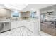 Bright kitchen featuring a skylight, stainless steel appliances, marble countertops, and white cabinets at 1756 Elinor Pl, Englewood, FL 34223