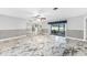 Bright living room with marble floors, ceiling fan, and access to the sunroom at 1756 Elinor Pl, Englewood, FL 34223