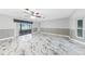 Bright living room with marble floors, ceiling fan, and access to the sunroom at 1756 Elinor Pl, Englewood, FL 34223
