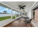Enclosed sunroom has a view of the backyard, with ceiling fans, outdoor carpet, and furniture at 1756 Elinor Pl, Englewood, FL 34223