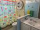 Bright bathroom with unique fish-themed decor, a shower and a white single sink vanity at 187 Beeney Se Rd, Port Charlotte, FL 33952