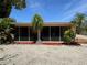 Rear exterior view with screen patio and tropical landscaping, offering a peaceful and private outdoor retreat at 187 Beeney Se Rd, Port Charlotte, FL 33952
