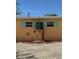 Exterior shot of home with mint-colored window accents and A/C unit on platform, surrounded by rock landscape at 187 Beeney Se Rd, Port Charlotte, FL 33952