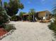 Single-story home boasting a well-kept gravel yard and tropical landscaping, enhancing its curb appeal and charm at 187 Beeney Se Rd, Port Charlotte, FL 33952