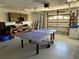 Spacious garage featuring a ping pong table, workbench, storage shelves, and ample room for activities at 187 Beeney Se Rd, Port Charlotte, FL 33952