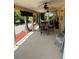 Inviting screened lanai with ceiling fans, tile flooring, and wooden dining set, perfect for outdoor relaxation at 187 Beeney Se Rd, Port Charlotte, FL 33952