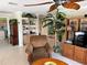 Cozy living room with ceiling fan, a wooden entertainment center, built-in shelves, and comfortable seating at 187 Beeney Se Rd, Port Charlotte, FL 33952