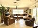 Spacious living room with comfortable seating, ceiling fan, and sliding glass doors leading to the outdoors at 187 Beeney Se Rd, Port Charlotte, FL 33952