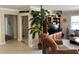 Inviting living room with a large plant, sliding glass door closet, and access to the bedroom and kitchen at 187 Beeney Se Rd, Port Charlotte, FL 33952