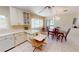 Bright eat-in kitchen featuring white cabinetry, tile floors, and large windows offering picturesque views of the neighborhood at 18954 Ayrshire Cir, Port Charlotte, FL 33948