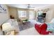 Light-filled living room with neutral decor, tile floors, and a large window for natural light with views of the front yard at 18954 Ayrshire Cir, Port Charlotte, FL 33948