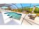 Inviting screened pool area with a view of the canal, boat dock, and surrounding landscaping at 18954 Ayrshire Cir, Port Charlotte, FL 33948