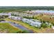 An aerial view shows colorful condo buildings next to a serene lake and convenient covered parking spaces at 2020 Willow Hammock Cir # 302, Punta Gorda, FL 33983