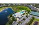 Aerial view showing the clubhouse, pool, parking area, and a serene lake with a fountain in a residential community at 2020 Willow Hammock Cir # 302, Punta Gorda, FL 33983