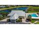 Aerial view of the clubhouse featuring a pool, pond with fountain, manicured landscaping, and ample parking at 2020 Willow Hammock Cir # 302, Punta Gorda, FL 33983