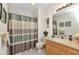 Bright bathroom featuring a single sink vanity, large mirror, and shower with striped curtain at 2020 Willow Hammock Cir # 302, Punta Gorda, FL 33983