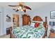 Inviting bedroom features ceiling fan, bed with tropical bedding, and ensuite bathroom at 2020 Willow Hammock Cir # 302, Punta Gorda, FL 33983