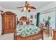 This bedroom features a bed with tropical bedding, ceiling fan, and custom armoire at 2020 Willow Hammock Cir # 302, Punta Gorda, FL 33983