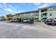 Exterior view of assigned parking and a stairway in front of this lovely, multi-story condo building on a sunny day at 2020 Willow Hammock Cir # 302, Punta Gorda, FL 33983