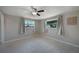 Cozy bedroom featuring tile floors, neutral walls, ceiling fan and plenty of natural light from two windows at 20215 Macon Ln, Port Charlotte, FL 33952