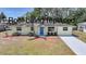 Inviting single-story home featuring a vibrant blue front door, well-maintained lawn, and lovely landscaping at 20215 Macon Ln, Port Charlotte, FL 33952