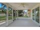 Enclosed lanai featuring a ceiling fan, concrete flooring, and screened windows with outdoor views at 20215 Macon Ln, Port Charlotte, FL 33952