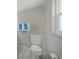 A bright bathroom with a white toilet, a gray tile floor, and a window providing natural light at 20215 Macon Ln, Port Charlotte, FL 33952