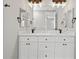 Elegant bathroom featuring a double sink vanity with white cabinets, marble countertops, and a large mirror at 2186 Florala St, North Port, FL 34287