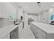 Modern kitchen featuring white cabinets, stainless steel appliances, and a large island with marble countertops at 2186 Florala St, North Port, FL 34287
